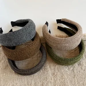 Zes brede gebreide haarbanden in zachte tinten, met pluizige textuur en een zwarte binnenband