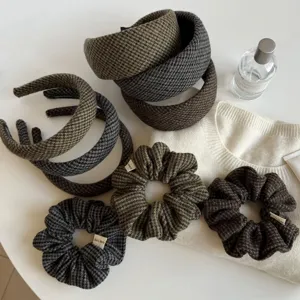 Bandeaux et chouchous en tissu à carreaux, verts, gris et bruns, près d’un tricot blanc