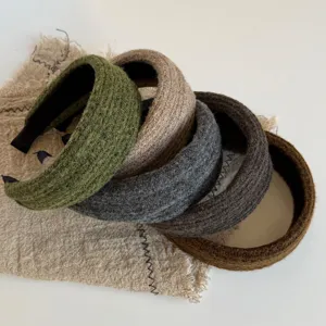 Vijf brede gebreide haarbanden in olijf, beige, grijs, donkerbruin en karamel met geribde textuur