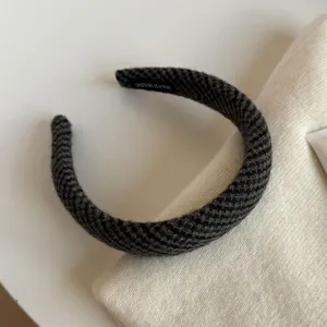 Gros plan sur la texture tissée gris foncé et la forme courbe et rembourrée du serre-tête