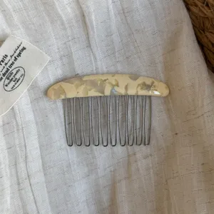 Close-up of a cream marbled hair comb with slender silver teeth and a small FRANCE handmade stamp