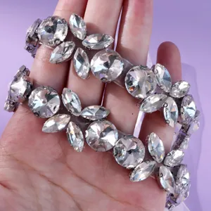 Silver-tone bridal waist chain with clear crystal floral motifs, displayed across a hand