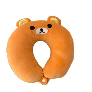 Orange plush bear-shaped U-shaped neck pillow with embroidered face and snap closure, front view