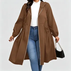Model wearing a brown hooded coat with drawstring waist, zip front and flared hem over jeans