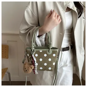 Borsetta in tessuto verde oliva a pois bianchi, con ciondolo a forma di orsetto e nastro decorativo