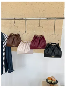 Quattro borse in similpelle arricciata, marrone, avorio, bordeaux e nero, con anelli dorati