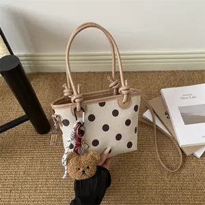 Borsetta color crema a pois marrone scuro, manici beige, tracolla e ciondolo a forma di orsetto