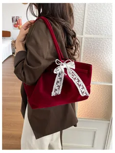 Burgundy velvet bag worn over the shoulder, featuring a white lace bow with pearl accents