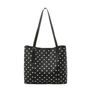 Borsa tote nera in similpelle a pois bianchi, con tracolla lunga e manici, vista frontale