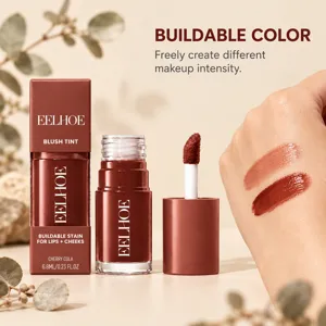 Close-up of cherry-brown tint swatched on a hand beside its open tube and applicator