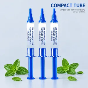 Tre siringhe blu e bianche da 3 ml con gel per l'igiene orale, accanto a foglie di menta fresca