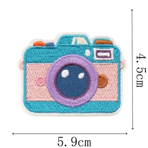 Detail van een kleurrijke geborduurde camerapatch met turquoise, roze en paarse steken, 5,9 × 4,5 cm