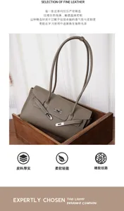 Graubraune Ledertasche mit Narbung und silbernem Drehverschluss, in einer Holzkiste präsentiert
