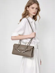Taupefarbene Schultertasche aus genarbtem Echtleder mit silbernem Drehverschluss, am Modell getragen