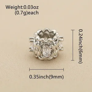 Gros plan sur une perle ajourée argentée, avec zircons transparents et motif floral sculpté