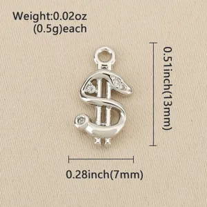 Close-up of a silver dollar-sign charm with clear stones and a top loop on beige fabric