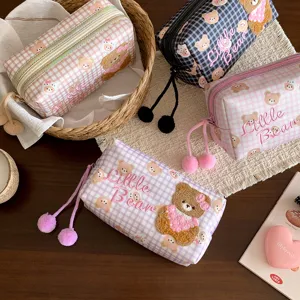 Mehrere karierte Pastelltäschchen mit Teddybär-Applikationen und Reißverschluss-Pompons