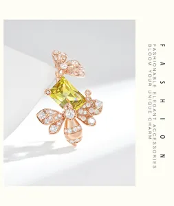 Dettaglio di una spilla ape in oro rosa, con pietre chiare e gemma giallo-verde sfaccettata