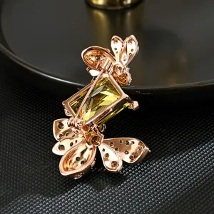 Spilla a forma d'ape in oro rosa con gemma rettangolare giallo-verde, vista dal retro con ago