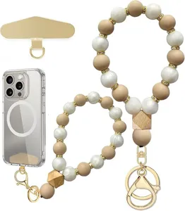 Close-up of beige and white beaded wrist straps with gold-tone spacers, wood charms and clasp