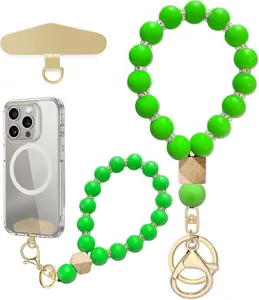 Close-up view of bright green beads, rhinestone spacers, wood accents, and gold-tone phone clips