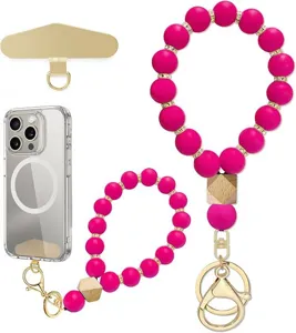 Close-up display of fuchsia bead wrist straps with gold spacers, wooden beads and metal key rings