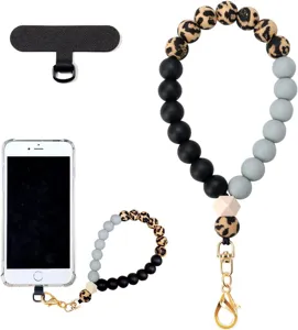 Flat lay showing a three-tone beaded wrist strap, gold clasp, phone patch tab and smartphone