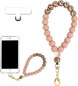 Close-up of a pink silicone bead phone wrist strap with leopard-print beads and gold clasp