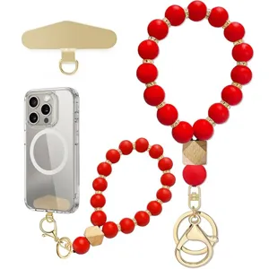Red silicone bead phone wrist strap set with wood accent beads and gold-tone clips on white