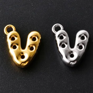 Close-up of gold and silver V-shaped metal pendants with loop tops and five circular openings