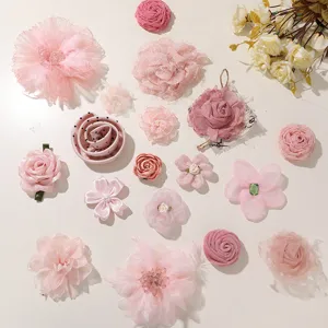 Overhead view of assorted pink fabric flowers with layered petals, pearls and rhinestone accents