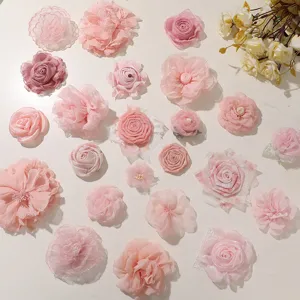 Overhead view of assorted pink fabric roses and ruffled flowers, some accented with pearls