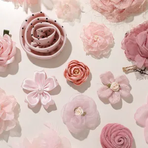 Overhead flat lay of pink fabric flowers in satin, chiffon and velvet, with pearl accents
