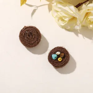 Flat lay of two brown twine nests, one empty and one holding small colorful beads