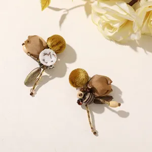 Pair of fabric floral earrings with gold and brown petals, ivory accents, wooden and glass beads