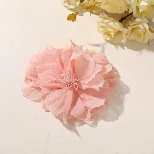 Close-up of a layered pink chiffon flower with frayed petal edges and a pale beaded center