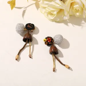 Flat lay of mismatched earrings with woven balls, brown pendants, bead chains and gold-tone pins
