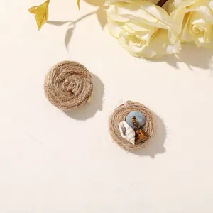 Two round jute-wrapped ornaments, one with a blue bead, shell and brown stone charm
