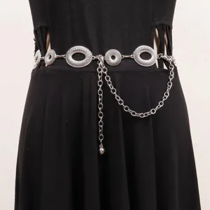 Close-up van een zilverkleurige tailleketting met opengewerkte ringen over een zwarte jurk