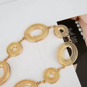 Close-up van een goudkleurige tailleketting met opengewerkte ovale en ronde schakels met reliëf