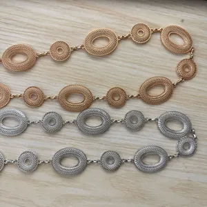 Vier opengewerkte metalen kettingen met ovale en ronde schakels in roségoud- en zilverkleur