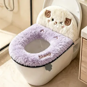 Close-up of a lavender plush toilet seat cover with a smiling sheep motif, shown on a white toilet