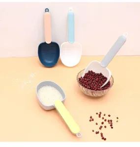 Misurini colorati in plastica con foro per appenderli, accanto a riso e fagioli rossi.