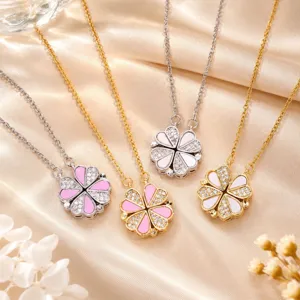 Vier Herzblüten-Anhänger mit klaren Steinchen in Rosa, Weiß, Gold und Silber auf Seide