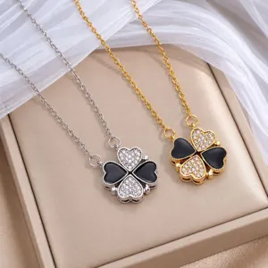 Zwei Kleeblattanhänger in Silber und Gold mit schwarzer Emaille und funkelnden Zirkonsteinen