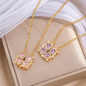 Nahaufnahme goldener Kleeblattanhänger mit rosa und violetten Herzen und klaren Glanzsteinen