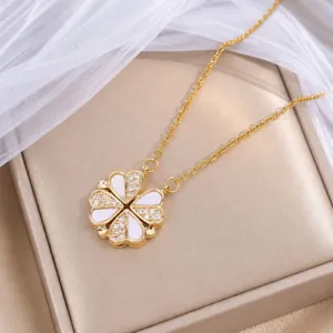 Kleeblattanhänger in Goldoptik mit weißen Blütenblättern und Glitzersteinen in beiger Schatulle