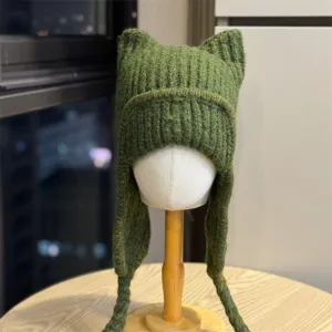 Green rib-knit texture with pointed cat ears and braided earflap ties, shown on a mannequin head.