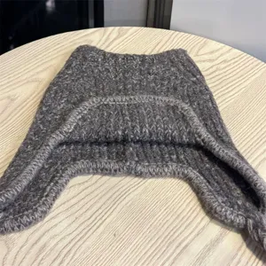 Flat lay showing the gray marled knit texture and folded edge of the winter headwear.