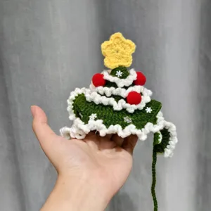 Hand-crocheted Christmas tree ornament in green and white, with red baubles and a yellow star